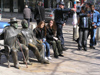 Sofia: people and statues on a bench - photo by J.Kaman