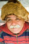 Punta Arenas, Chile: old Chilean man with mustache and wearing a beaver hat in a market stall - photo by D.Smith