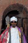 Lalibela, Amhara region, Ethiopia: Bet Mikael church - Coptic priest with cross and mequamia praying stick - photo by M.Torres