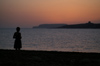 Malta - Comino: sunset - island silhouette seen from Marfa point in Malta - girl on the beach (photo by A.Ferrari)