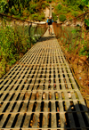 Sankhuwasabha District, Kosi Zone, Nepal: trekker crossing the Arun river on a suspension bridge - photo by E.Petitalot