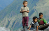 Nepal - Langtang region - poor children on a roof, looking down, mountains of Langtang national park in the background - photo by E.Petitalot