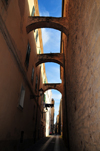 Alghero / L'Alguer, Sassari province, Sardinia / Sardegna / Sardigna: narrow street with arches - counter-thrust bows - photo by M.Torres