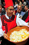 Cagliari, Sardinia / Sardegna / Sardigna: Feast of Sant'Efisio / Sagra di Sant'Efisio - man with a basket of rose petals for the 'Sa Ramadura' ritual - red coat of the militia, who in antiquity protected the procession from bandits along the coastal road - procession organised by the Arciconfaternita del Gonfalone - photo by M.Torres