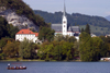 Slovenia - Gondolier rowing tourists across Lake Bled with Bled church in background - photo by I.Middleton