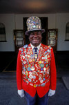 Victoria Falls - Mosi-oa-tunya, Matabeleland North province, Zimbabwe: Odwell Makamure, the famous doorman at the Victoria Falls Hotel proudly parades his collection of pins on his red coat and tall hat - photo by C.Lovell