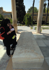 Iran - Shiraz: Mausoleum of Hafez - a woman read as poem by the Hafez's alabaster tombstone - photo by M.Torres